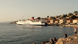 ferry arrivant sur la côte sarde avec village authentique